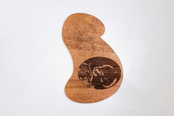 Stylized pregnant bust shaped wooden plaque, engraved with a sonogram image, on a white background