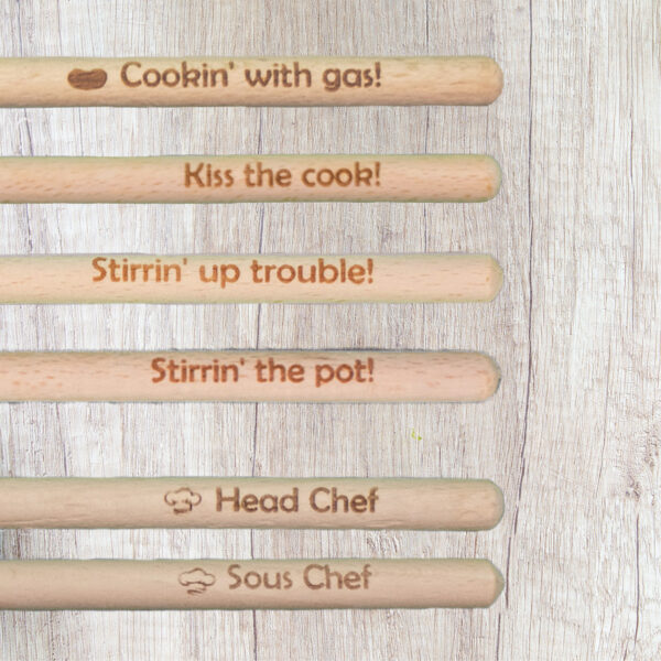 Engraved wooden spoon handles engraved with phrases, including Cookin' with gas, Kiss the cook, Stirrin' up trouble, Stirrin' the pot, Head chef, and Sous Chef.