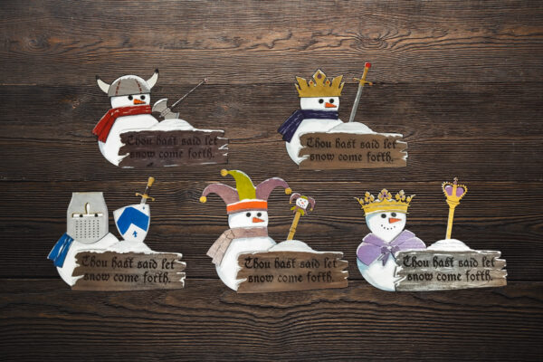 Finished Medieval Snowman plaques on a wood table. 5 designs displayed.