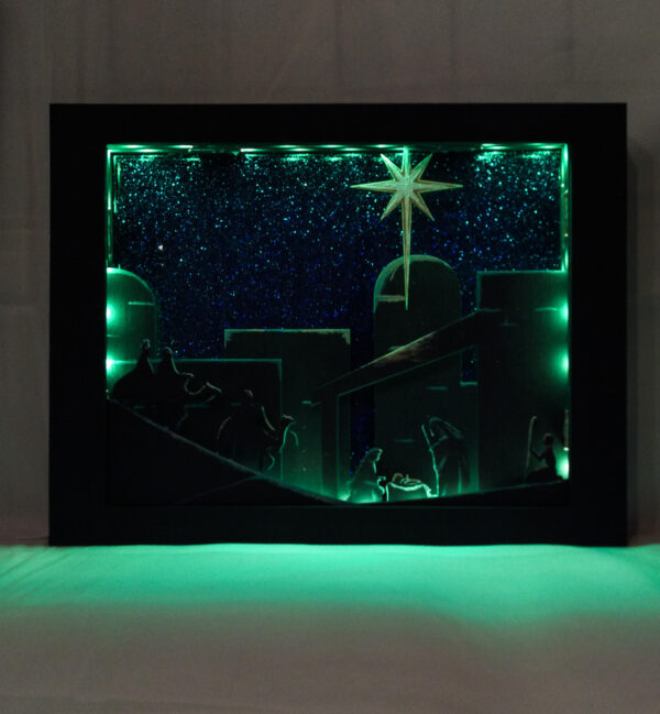 Beautiful 3d lightbox featuring a simple nativity scene illuminated with soft green light.