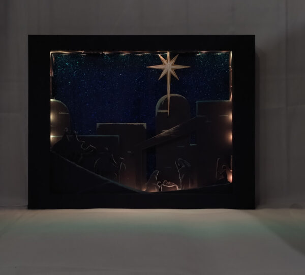 Beautiful 3d lightbox featuring a simple nativity scene illuminated with soft golden light.