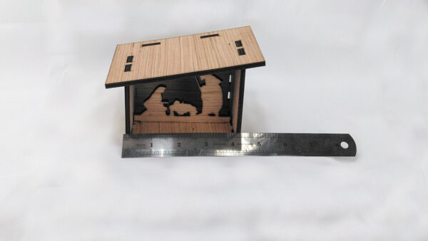 Bare wood Nativity scene with ruler.