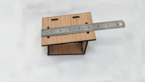 Bare wood Nativity scene with ruler.