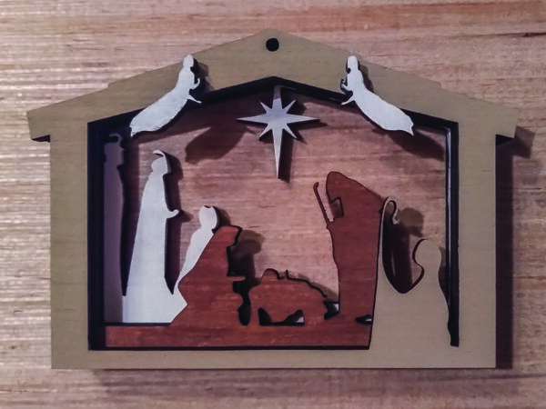 Layered 3D Nativity Christmas tree ornament, featuring the holy family in a stable, with wise men, shepherd, angels, and star. wood background.