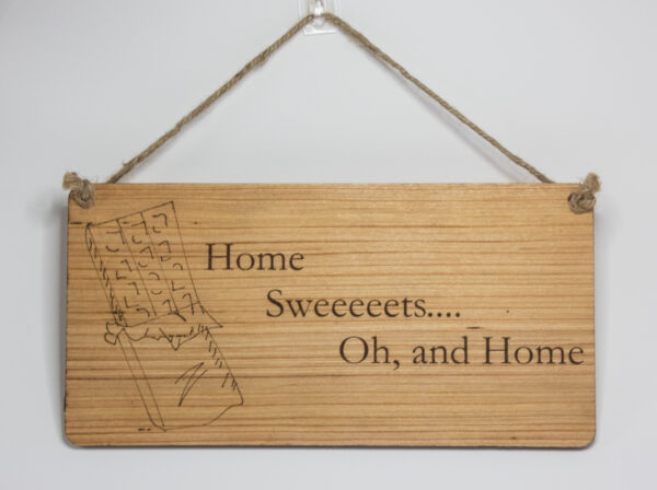 Laser engraved wood sign, featuring a chocolate bar and the text "Home Sweeeeeets... Oh, and home."