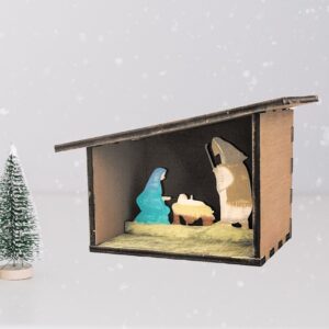 Painted 3D Nativity scene with a snowy background and small pine tree figure.