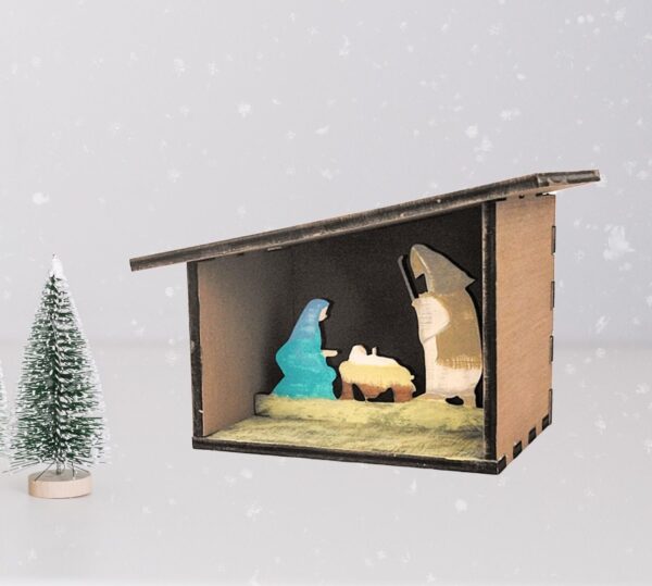 Painted 3D Nativity scene with a snowy background and small pine tree figure.