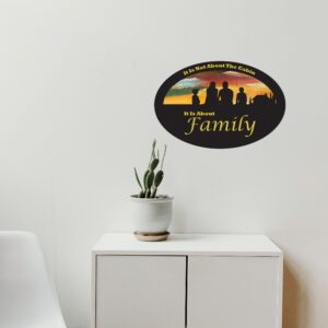 Oval-shaped sign with hand-painted sunset background and silhouette of a family and a cabin. Cutout text says "it is not about the Cabin, it is about family."